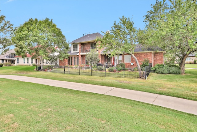 view of front of house with a fenced front yard, a front yard, and brick siding