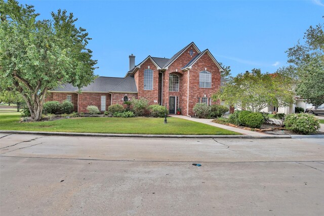 55 Monterrey Rd E, Montgomery, TX 77356 - traditional home featuring a chimney, brick siding, and a front yard