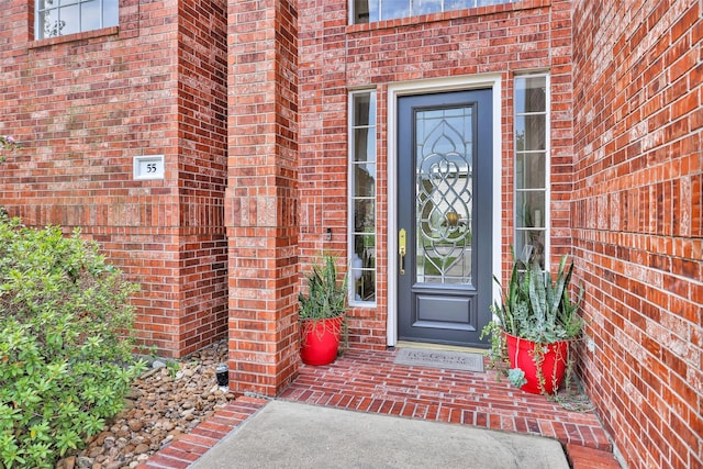 view of exterior entry with brick siding