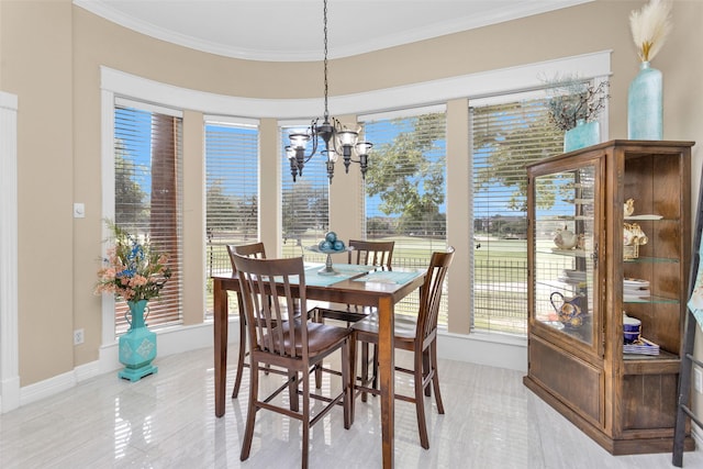 dining space with a notable chandelier, baseboards, and crown molding