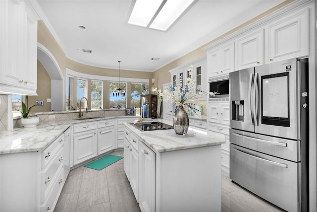 kitchen with stainless steel fridge, white cabinets, black stovetop, built in microwave, and a sink