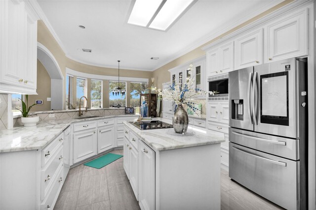 55 Monterrey Rd E, Montgomery, TX 77356 - kitchen with stainless steel fridge, a sink, cooktop, tasteful backsplash, and white cabinetry