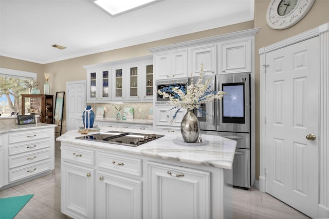 kitchen featuring tasteful backsplash, refrigerator with glass door, white cabinetry, and crown molding