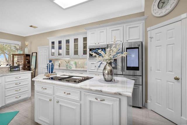 55 Monterrey Rd E, Montgomery, TX 77356 - kitchen featuring cooktop, tasteful backsplash, white cabinets, glass insert cabinets, and ornamental molding