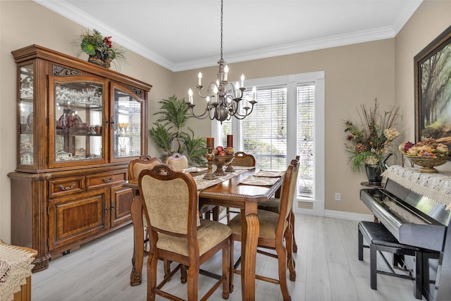 dining room with baseboards, crown molding, a notable chandelier, and light wood finished floors