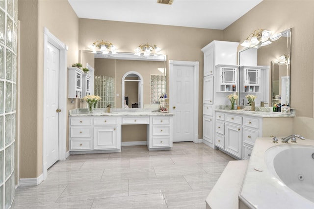 full bathroom featuring visible vents, baseboards, a jetted tub, and vanity