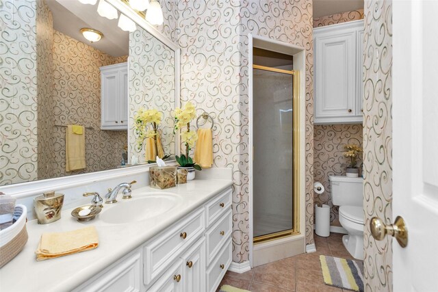 55 Monterrey Rd E, Montgomery, TX 77356 - bathroom with wallpapered walls, tile patterned floors, toilet, vanity, and a stall shower