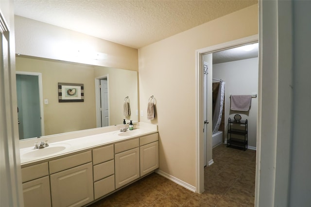 bathroom featuring double vanity, a textured ceiling, shower / bath combo, and a sink