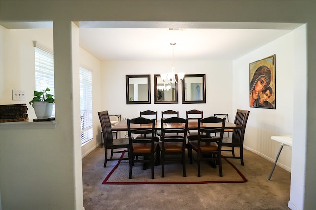 dining space with an inviting chandelier, carpet flooring, visible vents, and baseboards