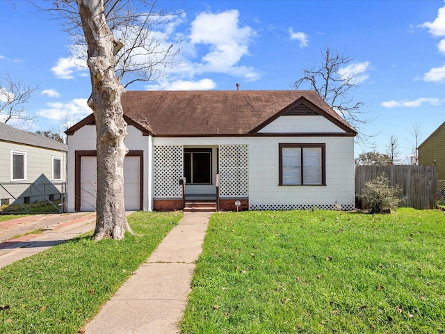 bungalow-style house featuring entry steps, a garage, fence, concrete driveway, and a front lawn