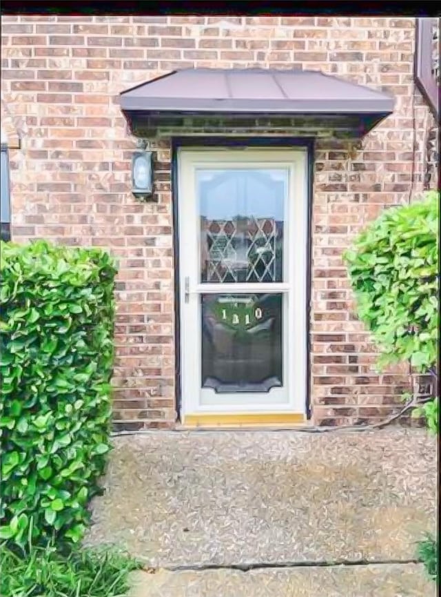 view of exterior entry with brick siding