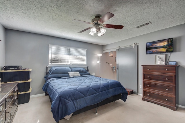 bedroom featuring ceiling fan, a textured ceiling, light colored carpet, visible vents, and baseboards