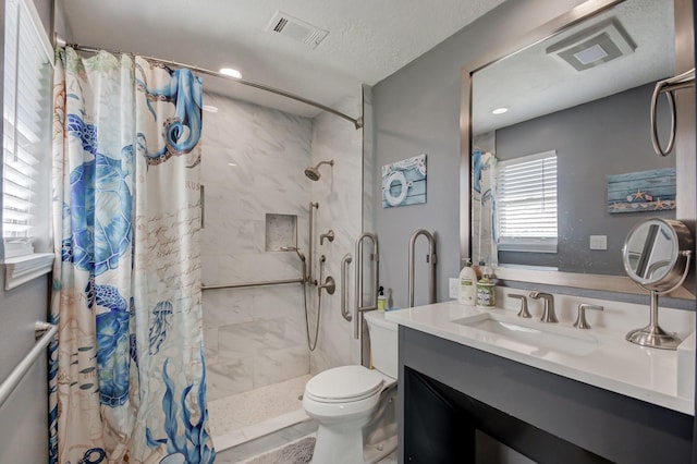 full bathroom featuring visible vents, toilet, a shower stall, and vanity