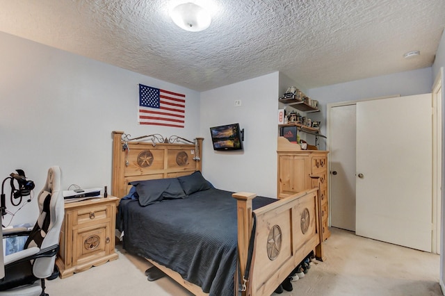 bedroom with light colored carpet and a textured ceiling