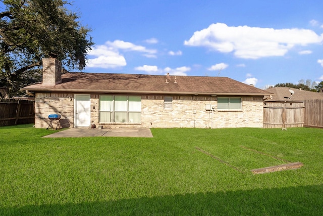 back of property with a lawn, a patio, a fenced backyard, a chimney, and brick siding