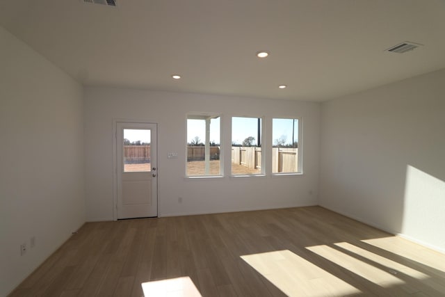 spare room featuring light wood-style flooring, visible vents, and recessed lighting