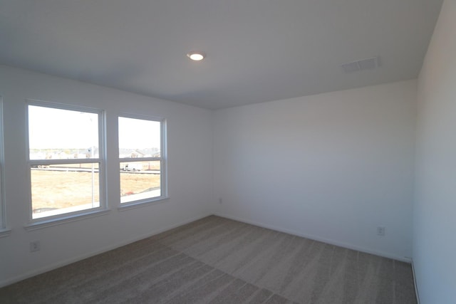 empty room featuring dark colored carpet, recessed lighting, visible vents, and baseboards