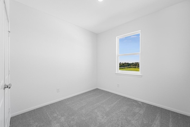 carpeted spare room featuring baseboards