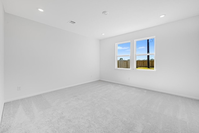 spare room with recessed lighting, visible vents, carpet flooring, and baseboards