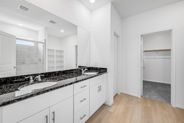 bathroom featuring a sink, visible vents, and a shower stall