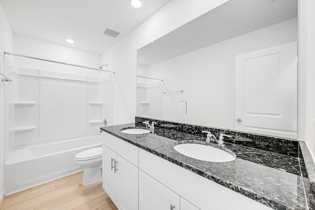 bathroom featuring double vanity, wood finished floors, visible vents, and a sink