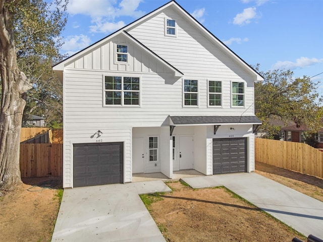 view of front of property with a garage, board and batten siding, and fence