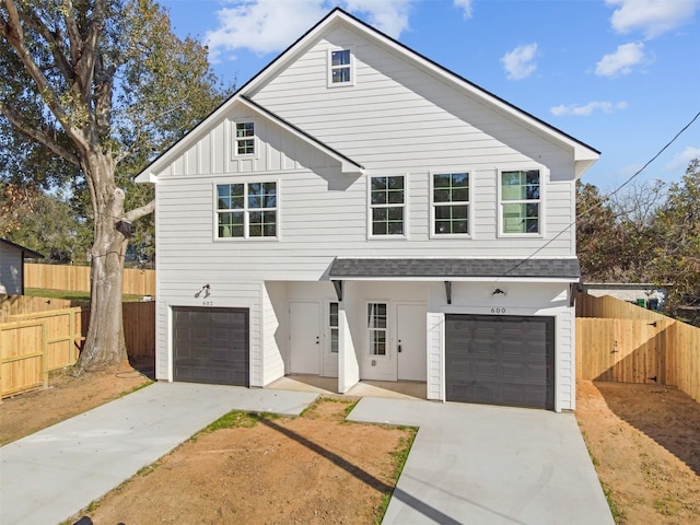 view of front of home featuring an attached garage, fence, board and batten siding, and concrete driveway