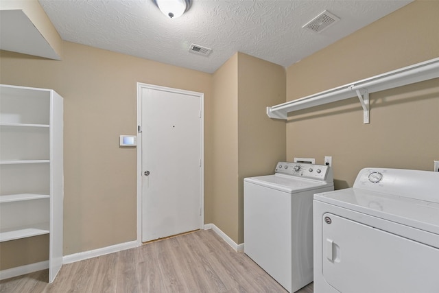 washroom with laundry area, visible vents, separate washer and dryer, and light wood-style floors