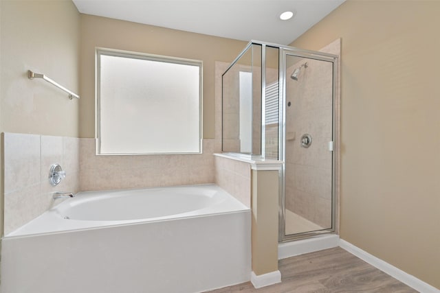 full bathroom featuring a garden tub, recessed lighting, a stall shower, wood finished floors, and baseboards