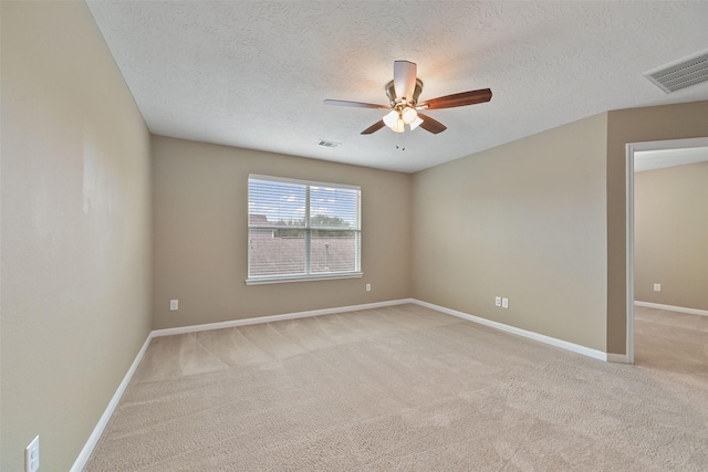 unfurnished room with light colored carpet, visible vents, ceiling fan, and baseboards