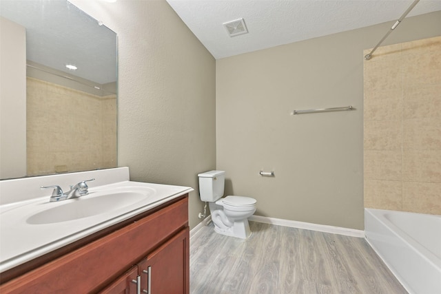 full bathroom with visible vents, toilet, wood finished floors, a textured ceiling, and vanity