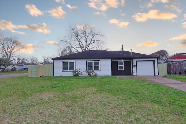 ranch-style home featuring a garage, driveway, a lawn, and fence