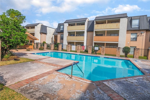 community pool with a residential view and fence