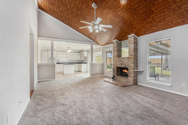 unfurnished living room featuring wooden ceiling, light colored carpet, a brick fireplace, a wealth of natural light, and crown molding