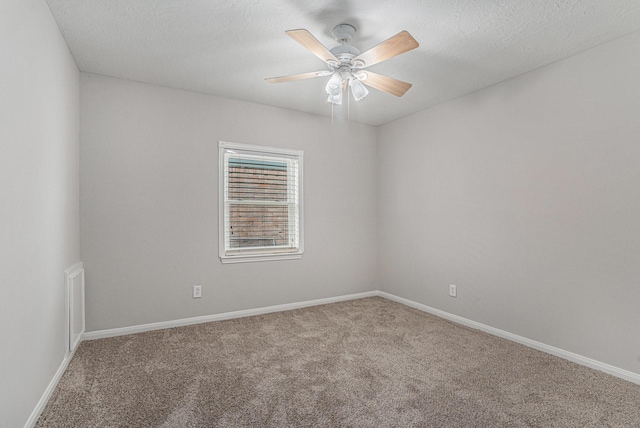 spare room with a ceiling fan, carpet flooring, a textured ceiling, and baseboards