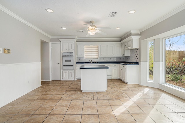 kitchen featuring dark countertops, white cabinets, visible vents, and light tile patterned flooring