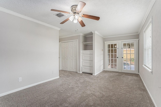 unfurnished bedroom featuring crown molding, a textured ceiling, visible vents, and light colored carpet