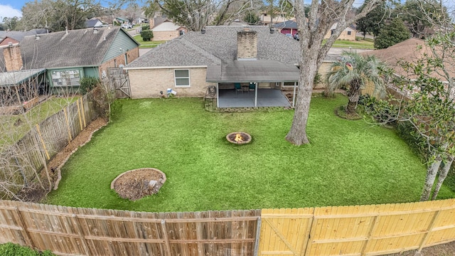 view of yard featuring a patio, an outdoor fire pit, a fenced backyard, and a residential view