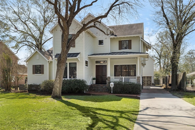 view of front facade with a porch, a front yard, a standing seam roof, and metal roof