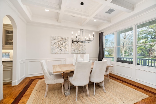 dining area with coffered ceiling, visible vents, light wood-style floors, beamed ceiling, and an inviting chandelier