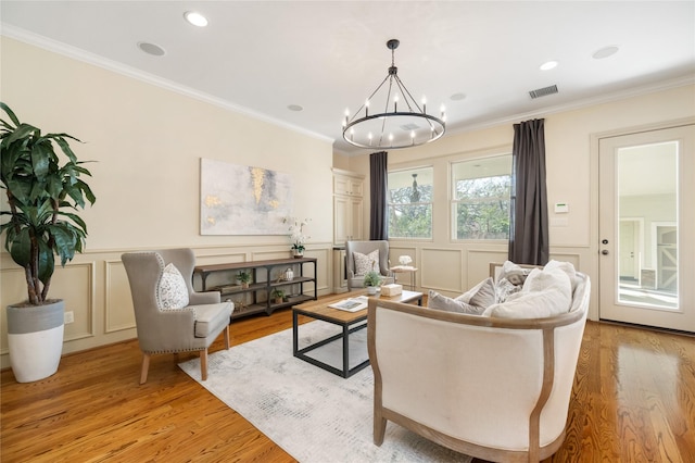 living area featuring light wood-type flooring, visible vents, and crown molding