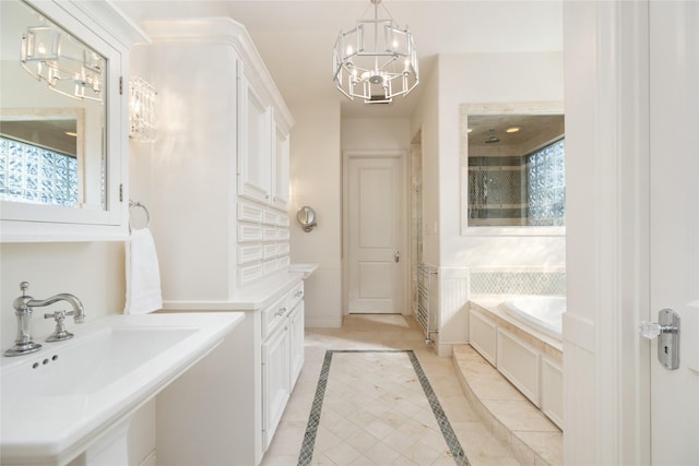 full bathroom featuring wainscoting, a sink, a bath, and an inviting chandelier