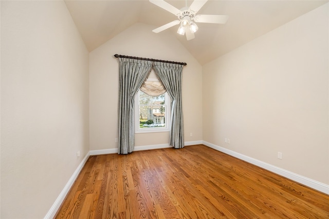 unfurnished room featuring a ceiling fan, lofted ceiling, baseboards, and wood finished floors