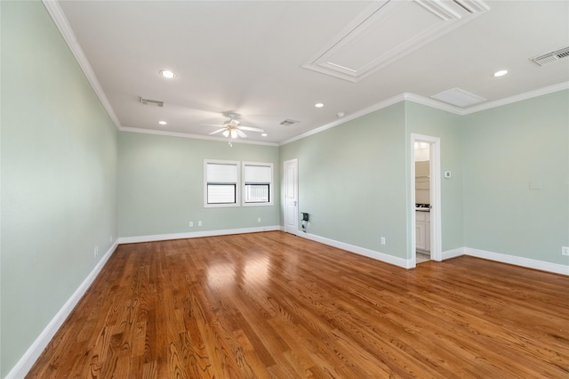 empty room with baseboards, wood finished floors, visible vents, and attic access