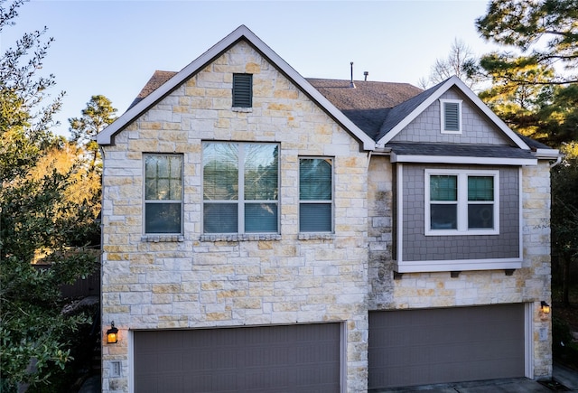 view of front of home with a shingled roof and an attached garage