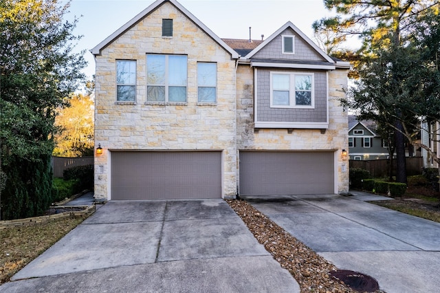 view of front of property featuring driveway, an attached garage, and fence