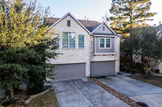 view of front of house featuring a garage, driveway, and stone siding