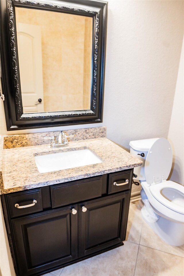 bathroom with toilet, tile patterned floors, and vanity