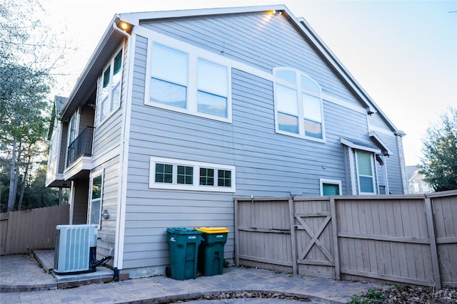 back of house with central AC, fence, and a gate