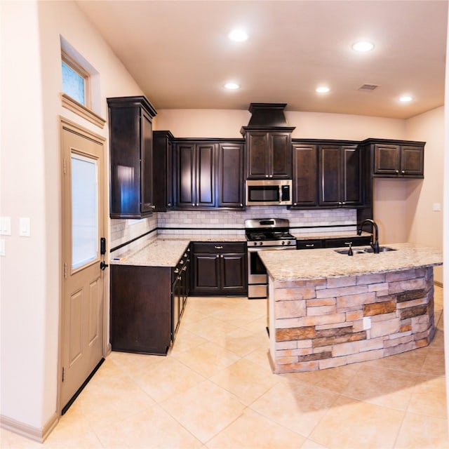 kitchen featuring appliances with stainless steel finishes, visible vents, a sink, and decorative backsplash